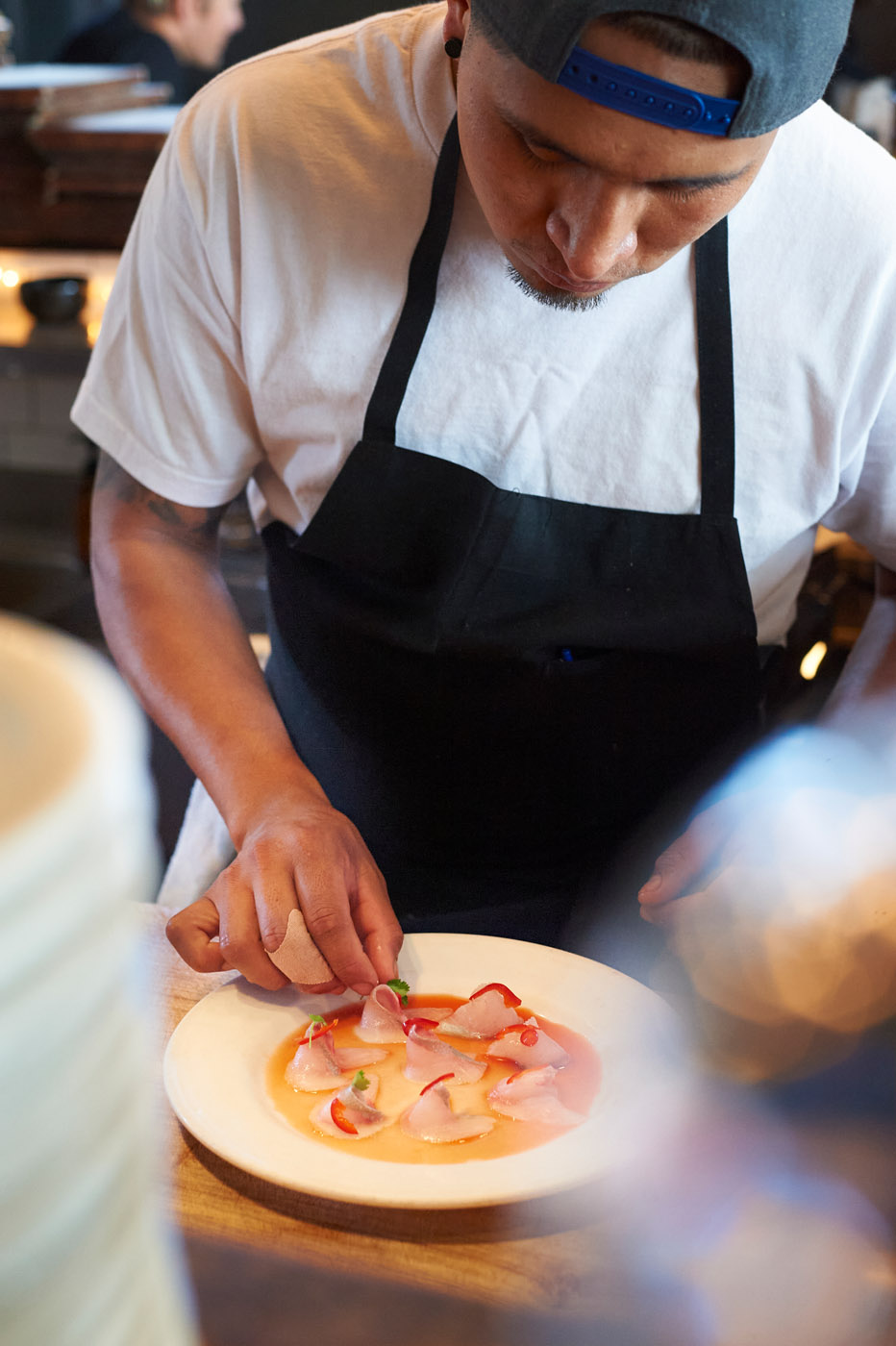 chef plating dish with fish